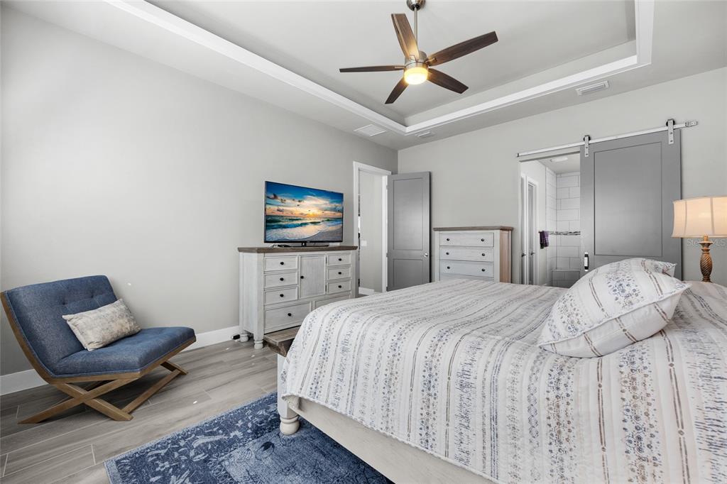 11949 Southwest 33 Lane Gainesville, FL 32608 - Photo 19 of 43 a spacious bedroom with a bed and a flat screen tv