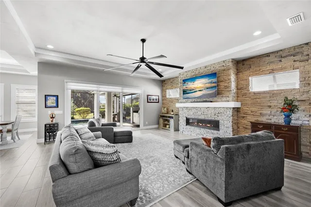 a living room with furniture a fireplace and a ceiling fan