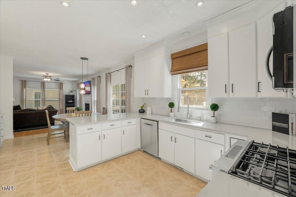 9813 Rockledge Drive Raleigh, NC 27617 - Photo 12 of 52 a kitchen with a sink stove and cabinets