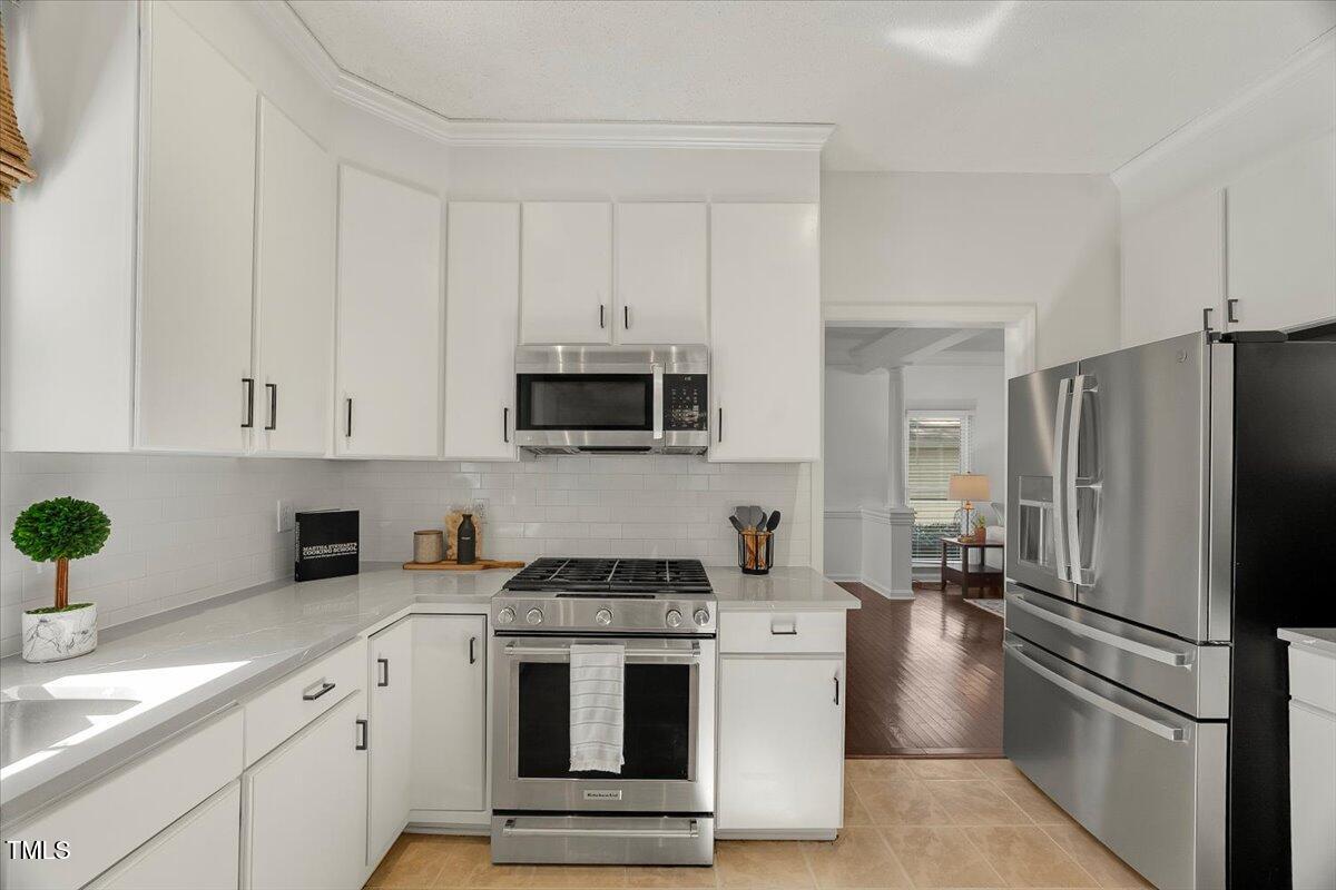9813 Rockledge Drive Raleigh, NC 27617 - Photo 15 of 52 a kitchen with stainless steel appliances white cabinets and a refrigerator