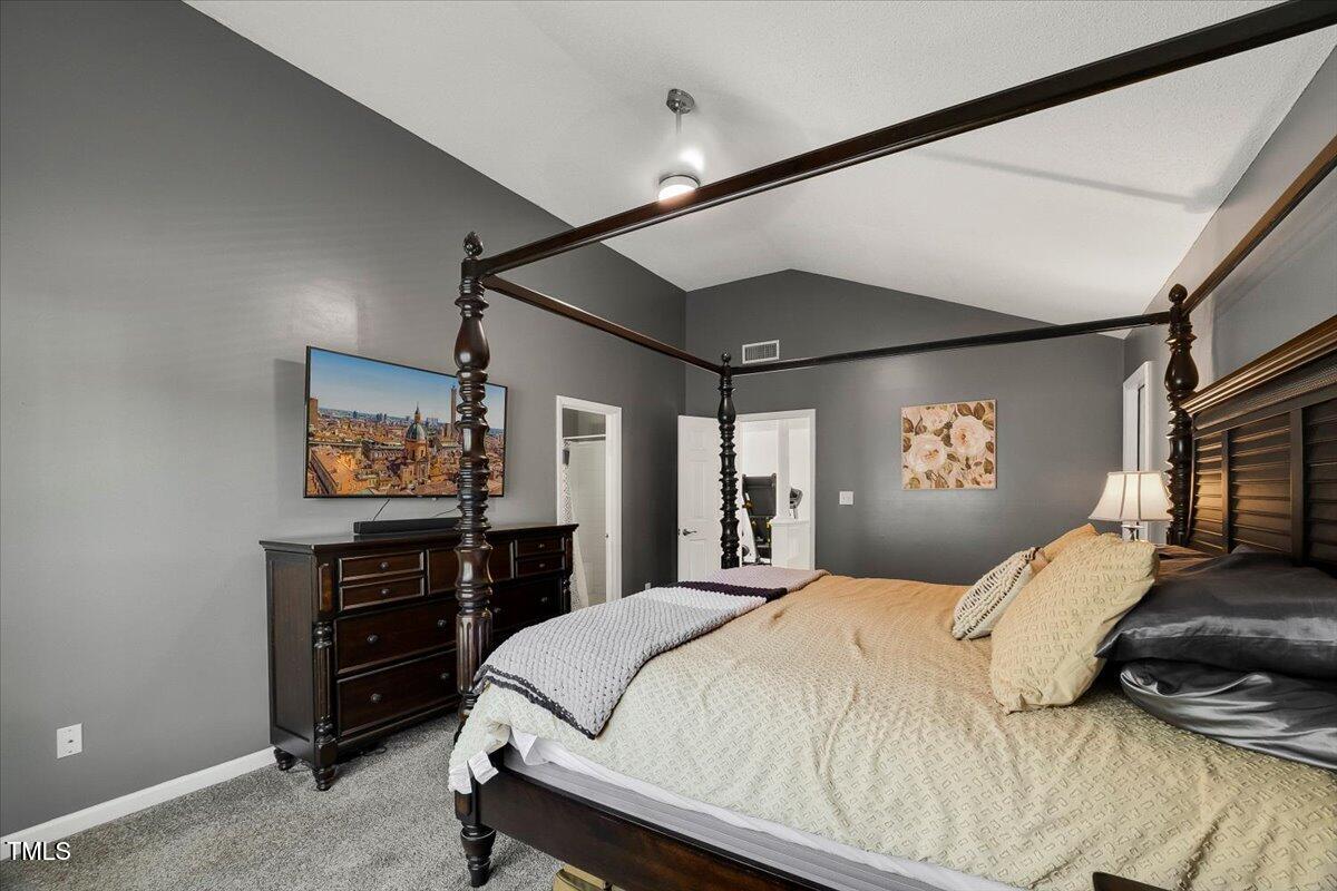 9813 Rockledge Drive Raleigh, NC 27617 - Photo 40 of 52 a bedroom with a bed and a flat tv screen on dresser