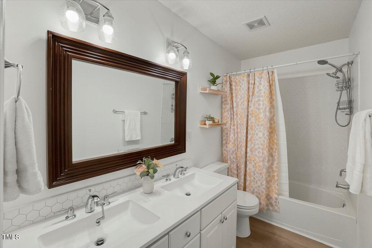 9813 Rockledge Drive Raleigh, NC 27617 - Photo 47 of 52 a bathroom with a sink double vanity mirror and a bathtub