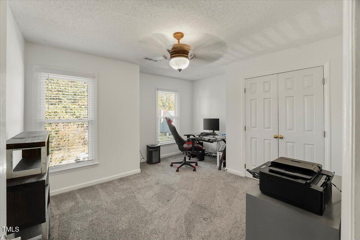 9813 Rockledge Drive Raleigh, NC 27617 - Photo 48 of 52 a living room with furniture a chandelier and a window