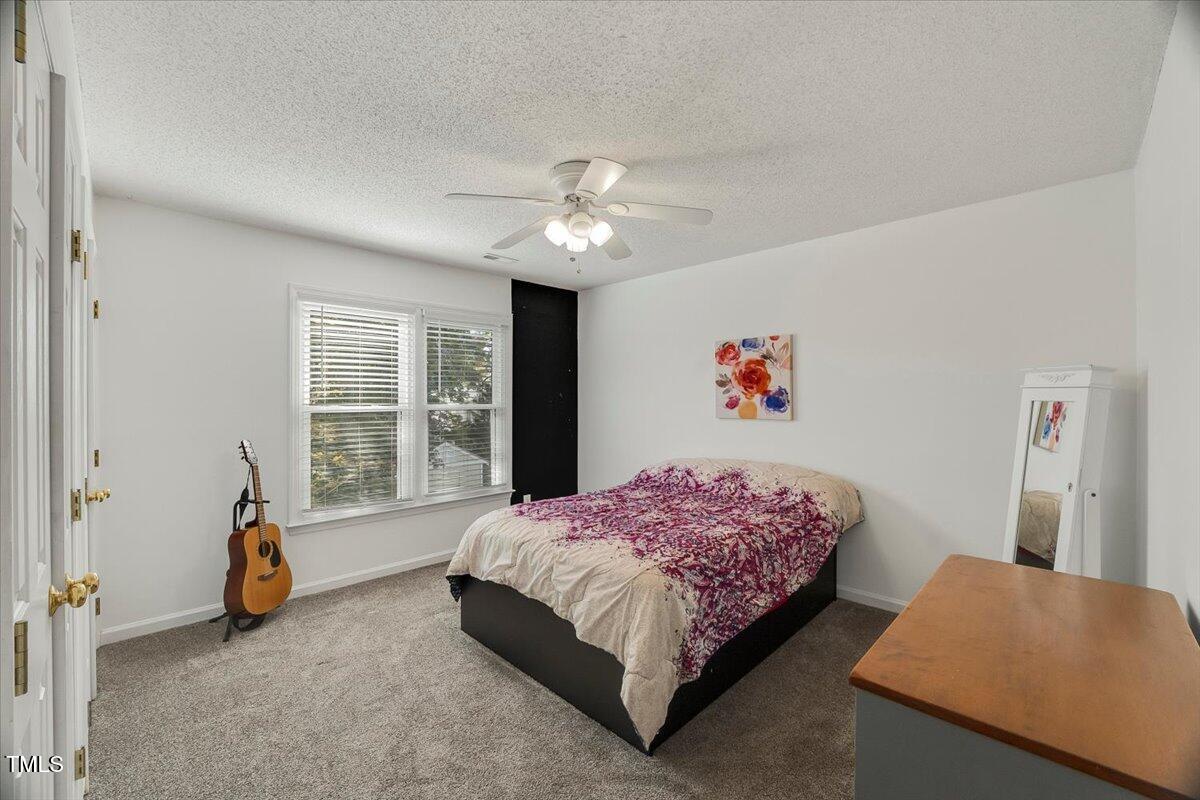 9813 Rockledge Drive Raleigh, NC 27617 - Photo 49 of 52 a bedroom with a bed and a chandelier