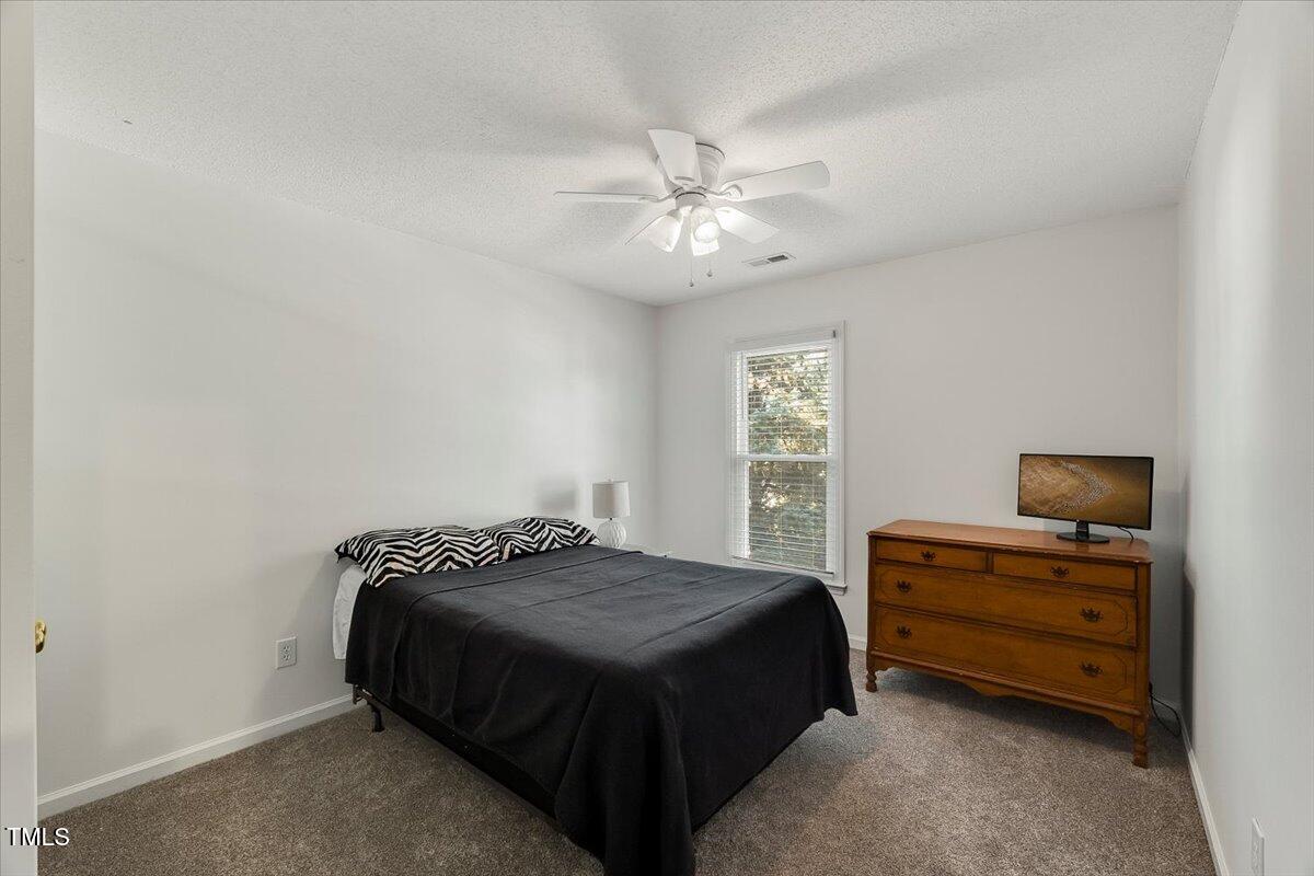 9813 Rockledge Drive Raleigh, NC 27617 - Photo 51 of 52 a bedroom with a bed dresser and a window