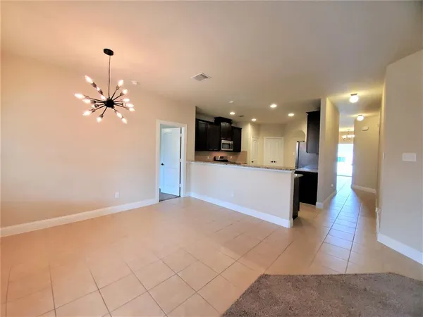 a view of a kitchen with kitchen island a sink wooden floor and a refrigerator