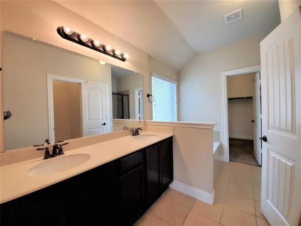 a bathroom with a double vanity sink a and mirror