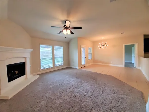 a view of empty room with fan and fireplace