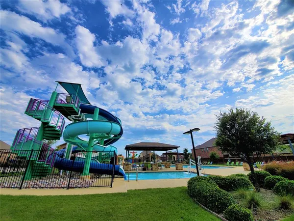 a view of yard with swimming pool and green space