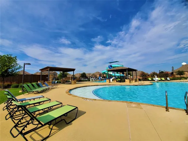 a view of a swimming pool and lounge chairs