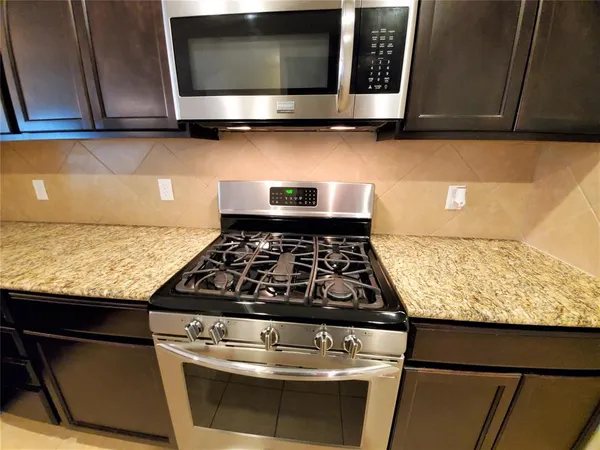 a stove top oven sitting inside of a kitchen
