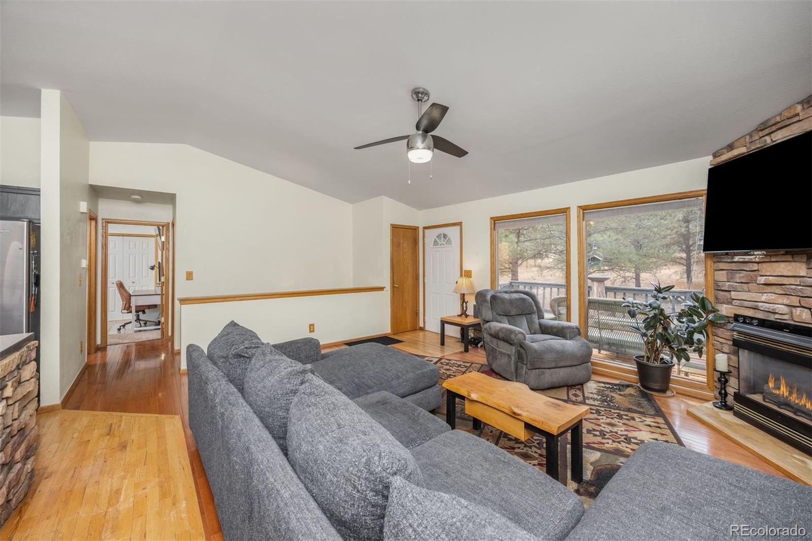 1768 Bluebird Drive Bailey, CO 80421 - Photo 11 of 50 a living room with furniture flat screen tv and a fireplace