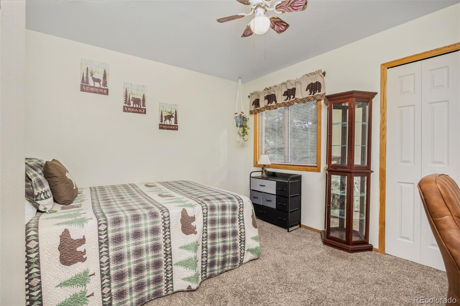 1768 Bluebird Drive Bailey, CO 80421 - Photo 17 of 50 a bedroom with a bed a dresser and chair