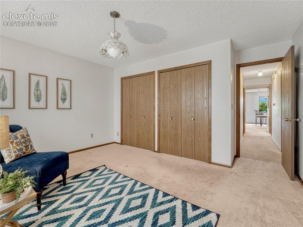 1146 Fontmore Road, Unit A Colorado Springs, CO 80904 - Photo 23 of 24 a spacious bedroom with a bed and a chandelier