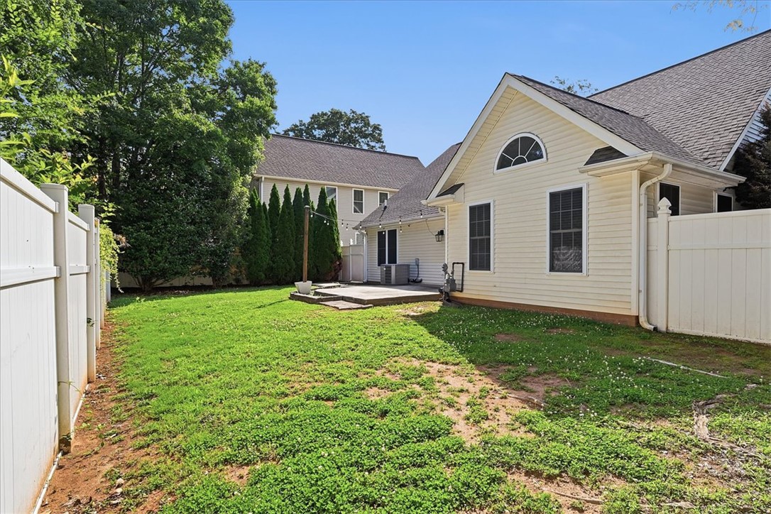101 Grand Oak Circle Pendleton, SC 29670 - Photo 30 of 40 A pristine backyard with a manicured lawn features a privacy fence and a concrete patio.