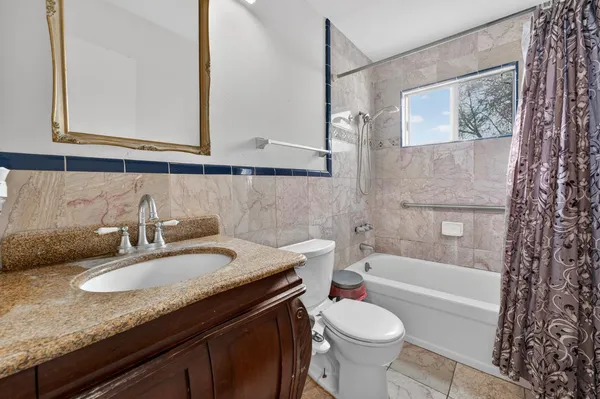 a bathroom with a granite countertop sink toilet and shower