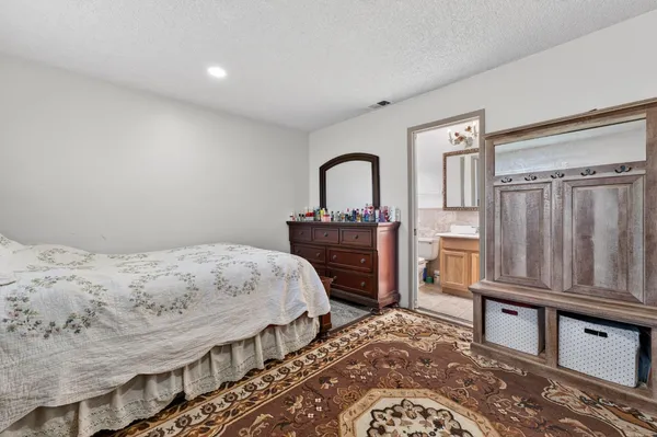 a bedroom with a bed next to a window with the dresser