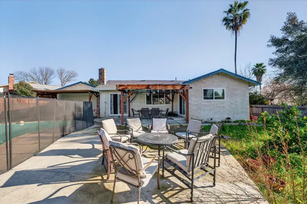 a view of a house with backyard and sitting area