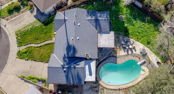 an aerial view of a house with garden space and street view