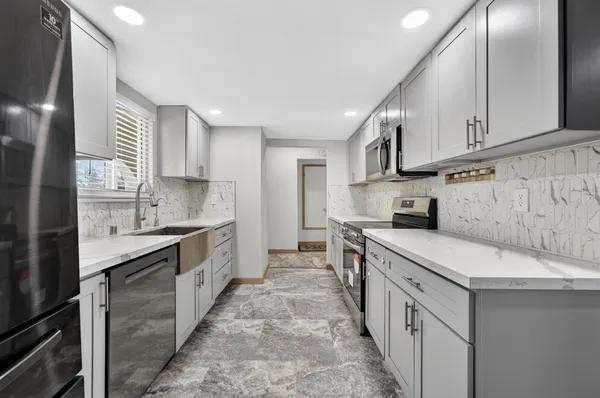 a kitchen with stainless steel appliances sink a stove and cabinets