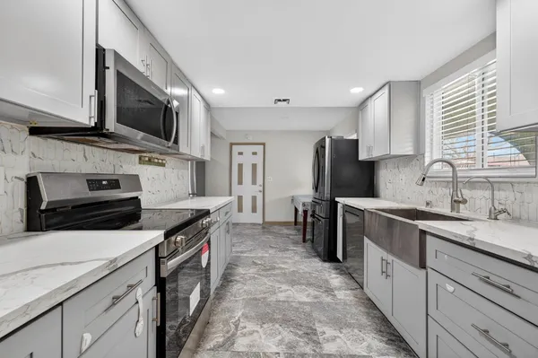 a kitchen with stainless steel appliances a stove sink microwave and cabinets