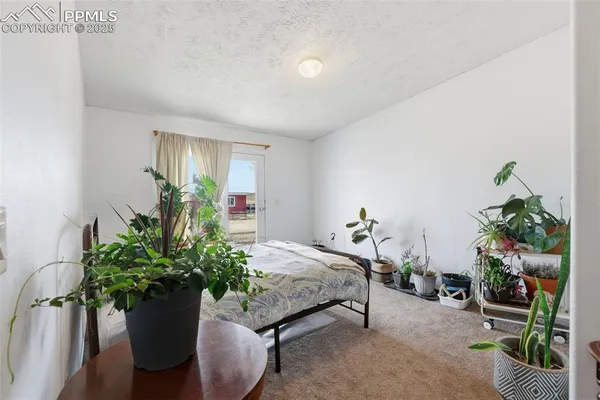 a bedroom with a bed and a potted plant