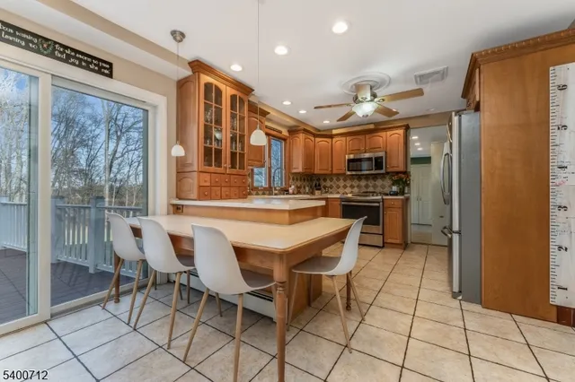 a dining hall with stainless steel appliances granite countertop a refrigerator and a stove top oven