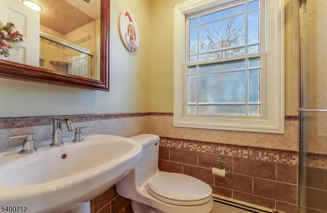 a bathroom with a toilet a sink and mirror