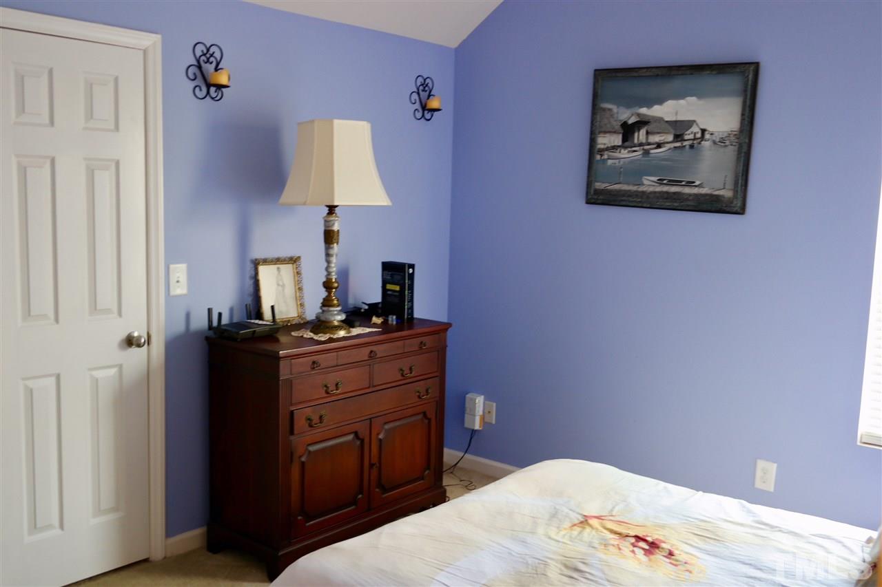 1012 Lombar Street Raleigh, NC 27610 - Photo 16 of 20 a bedroom with a bed and a lamp on dresser