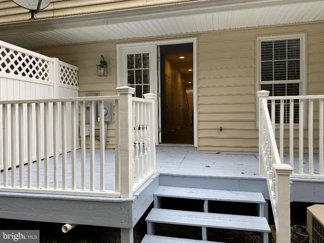 a view of a hallway with wooden floor and a living room