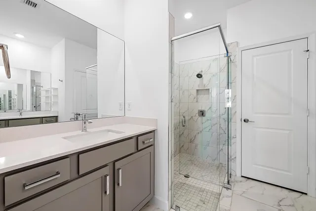 a bathroom with a shower sink and mirror