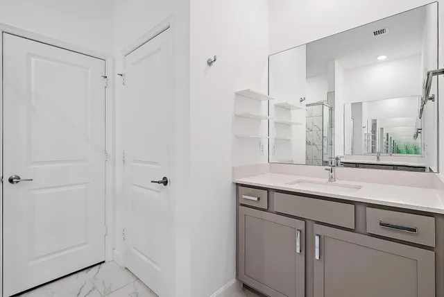 a bathroom with a granite countertop sink and a mirror