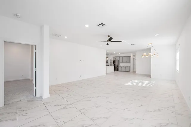an empty room with kitchen and windows