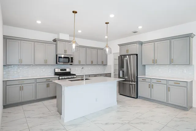 a kitchen with kitchen island granite countertop cabinets and stainless steel appliances