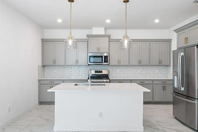 a kitchen with a sink a microwave a refrigerator and cabinets