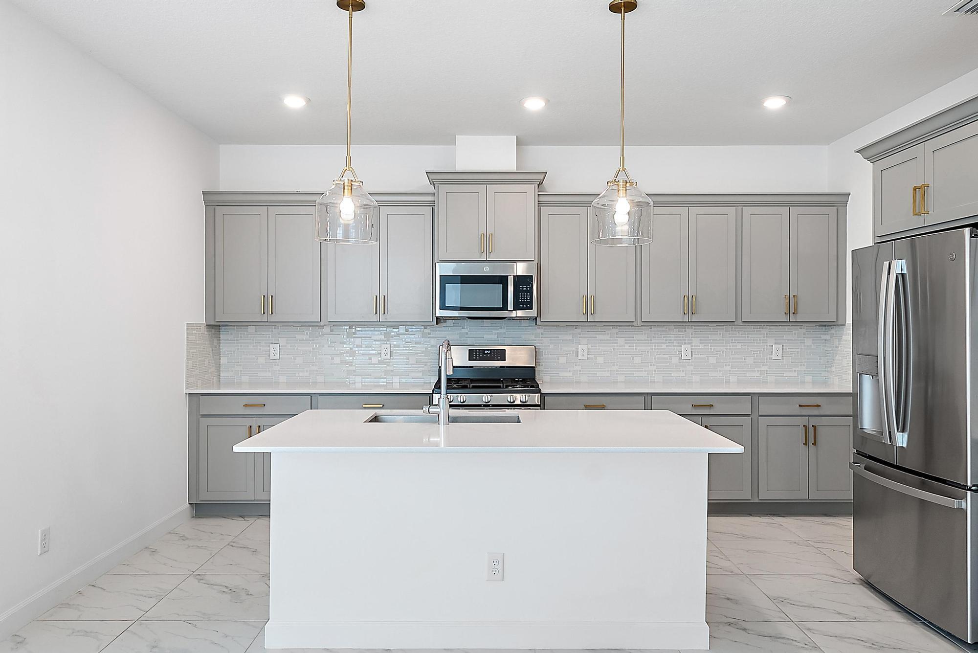 1283 Tangled Orch Trace Loxahatchee, FL 33470 - Photo 8 of 21 a kitchen with a sink a microwave a refrigerator and cabinets
