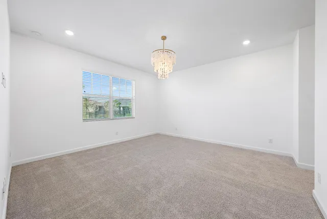 an empty room with windows and ceiling fan