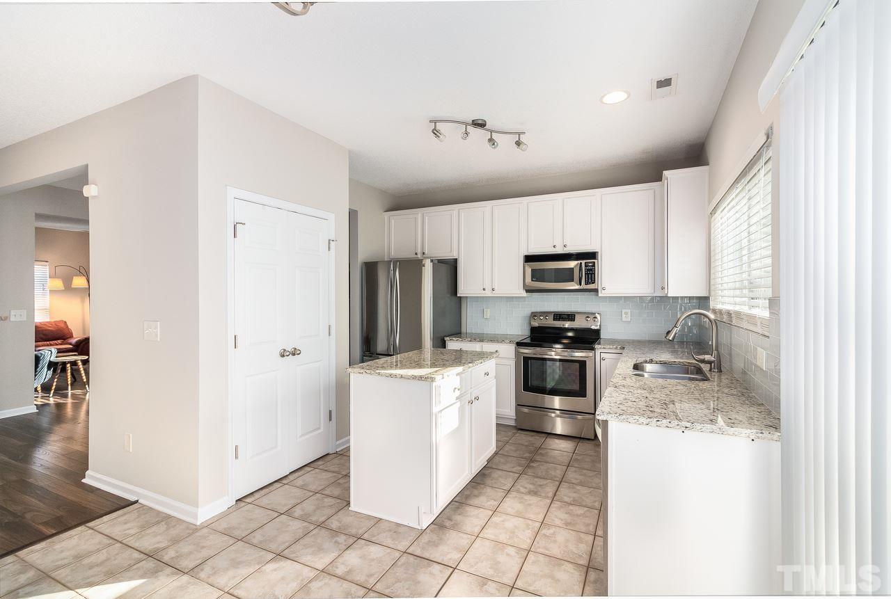 8 Sharpstone Lane Durham, NC 27703 - Photo 7 of 15 a kitchen with granite countertop a refrigerator and a stove top oven