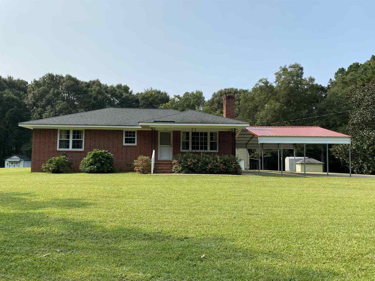 a front view of house with yard and green space