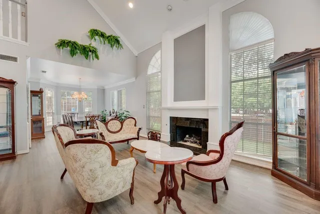 a living room with furniture a large window and wooden floors