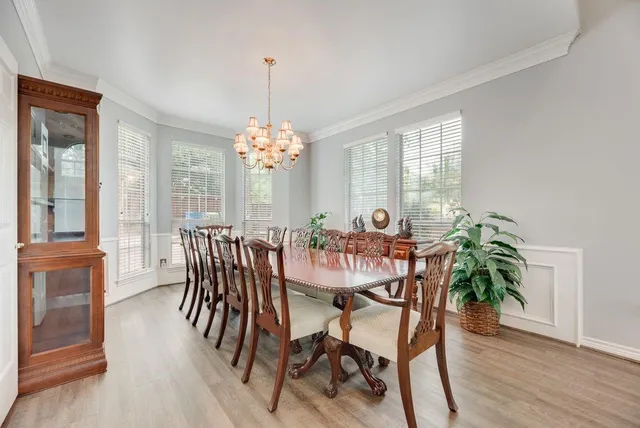 a dining room with furniture a chandelier and wooden floor