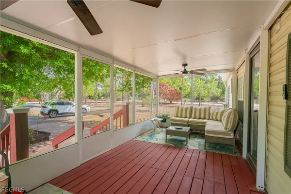 a living room with furniture fireplace and large windows