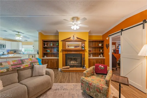 a kitchen with a sink dishwasher a stove a microwave oven and a dining table with wooden floor