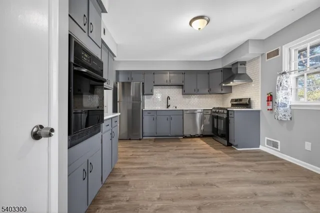 a view of a kitchen with wooden floor and electronic appliances