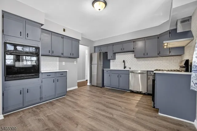 a kitchen with granite countertop a sink cabinets and stainless steel appliances