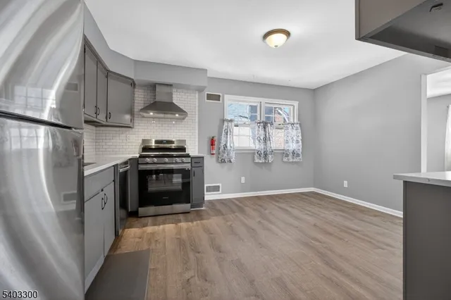 a kitchen with stainless steel appliances a stove a sink and a refrigerator