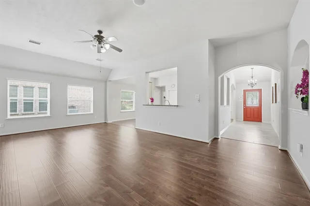 a view of an empty room with window and wooden floor