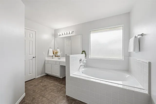 a spacious bathroom with sink shower and bathtub