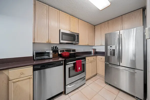 a kitchen with refrigerator a microwave a sink and cabinets