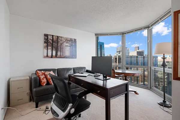 a view of a workspace with furniture and a window